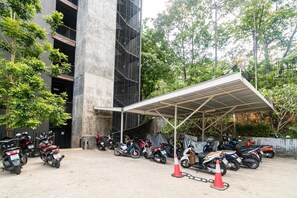 Park your motorcycle under the covered shelter near the building with a sleek, contemporary design.