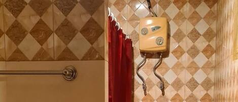 A bathroom with a toilet, bidet, and shower.