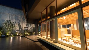 A modern building with large glass windows, wooden furniture, and outdoor seating. - OnnNakatsugawa (Nakatsugawa)