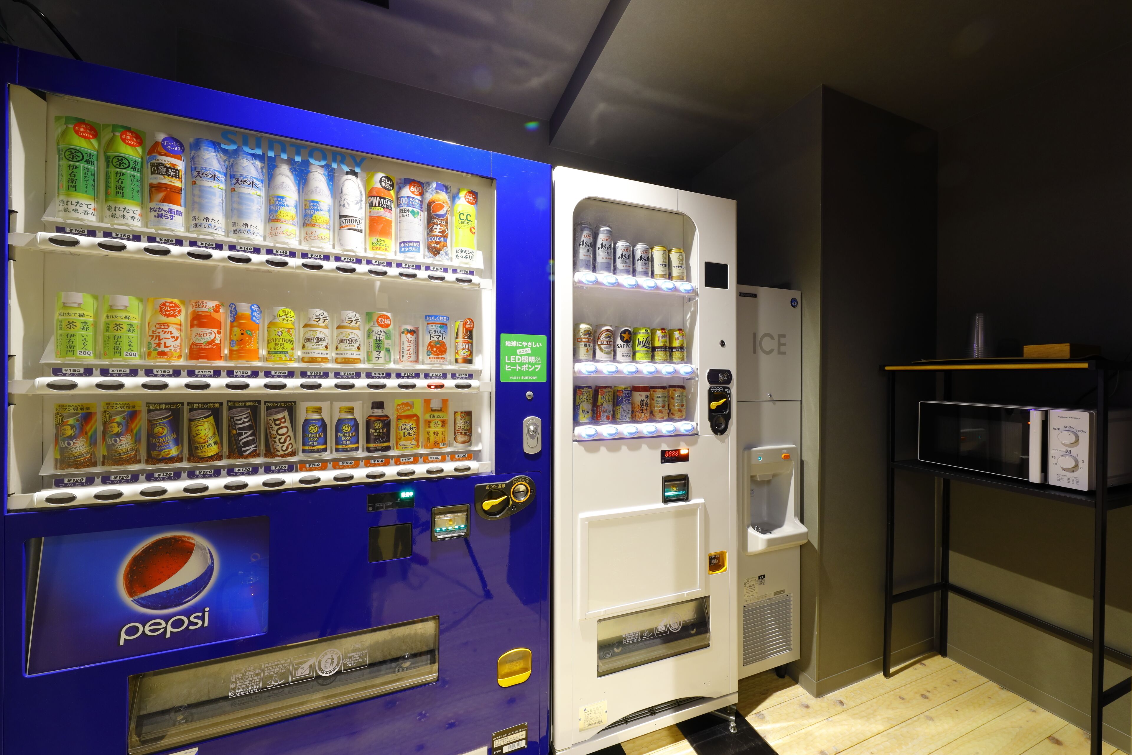 A vending machine with a Pepsi logo, various drinks, and a microwave.