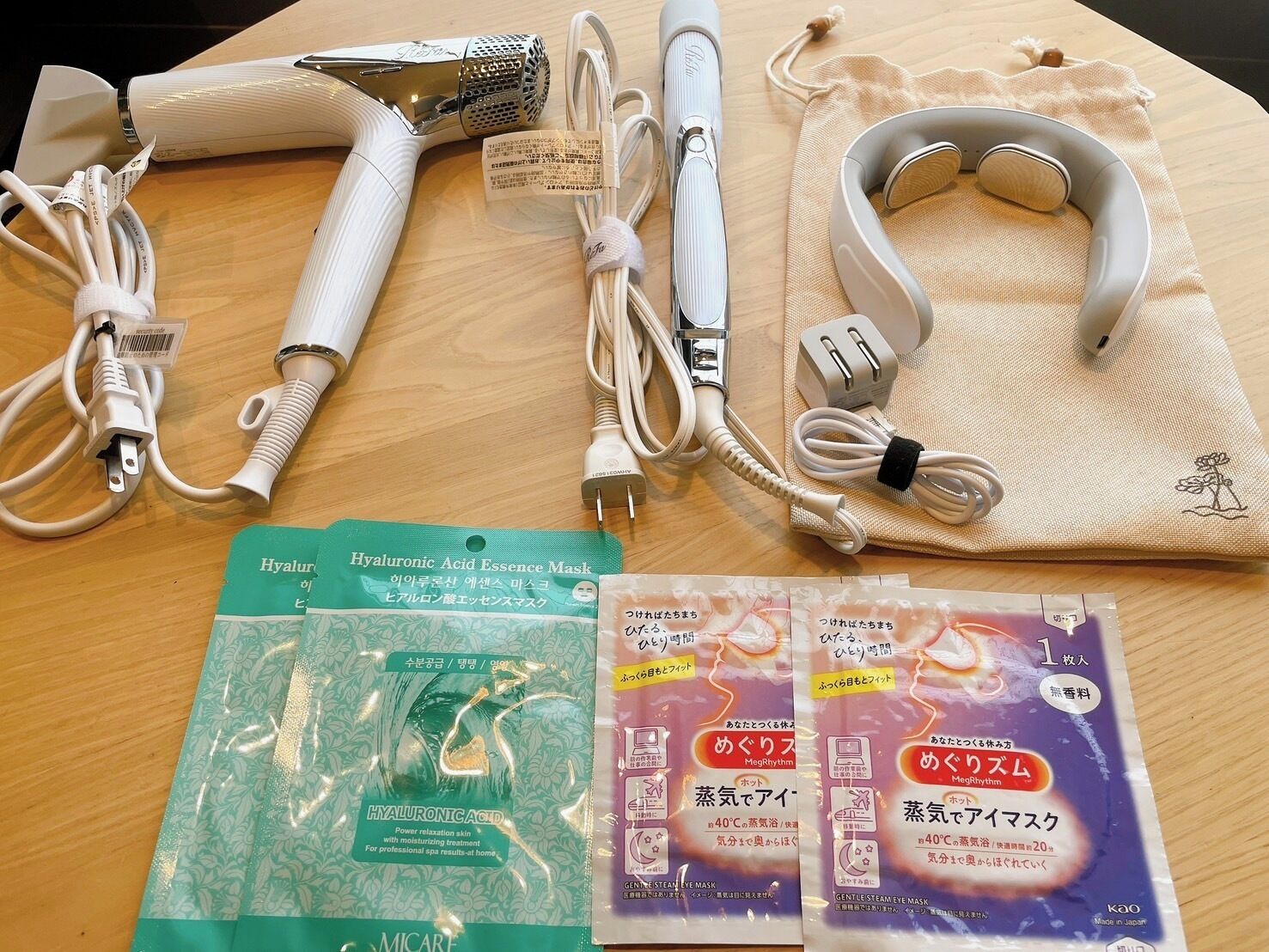 Una mesa con varios productos para el cuidado de la piel, incluyendo un vaporizador facial, una mascarilla facial y una máscara para los ojos con vapor.