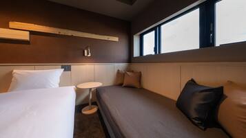 A hotel room with a bed, a small round table, and a window with a view.