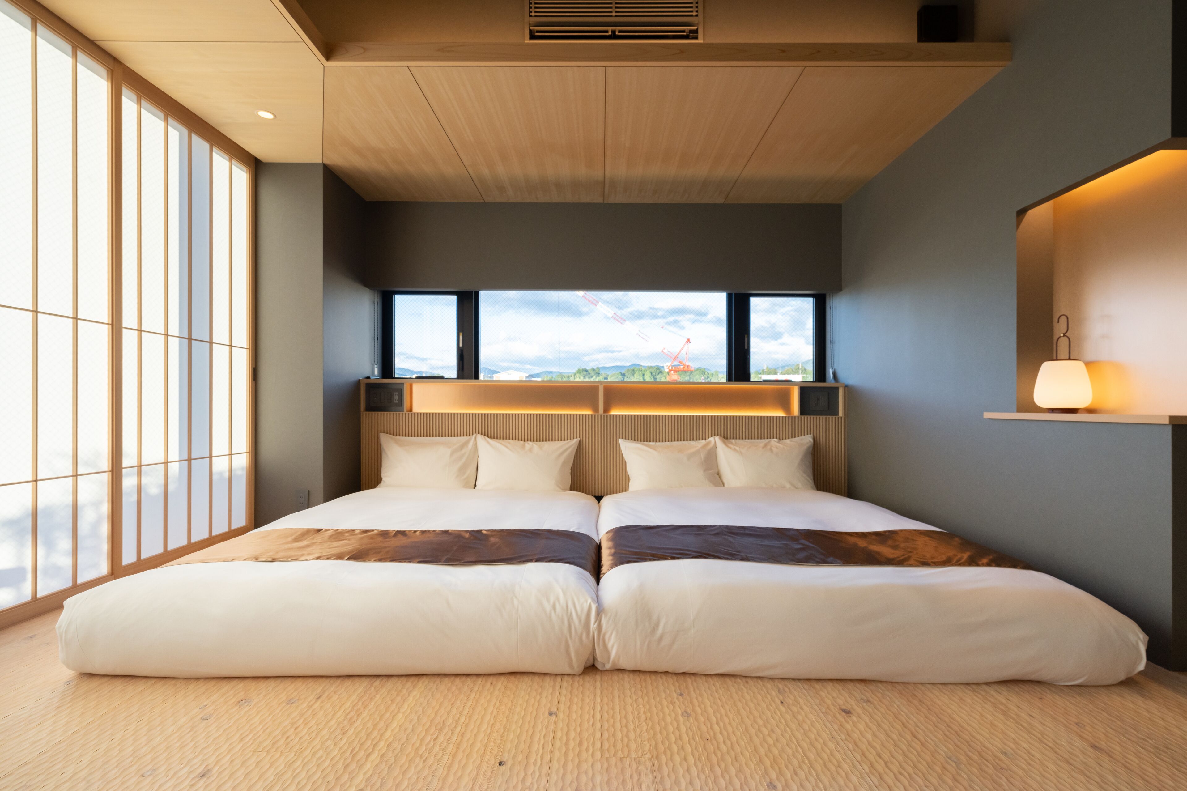 Una habitación de hotel moderna con una cama grande, vistas de la ciudad y un techo de madera.