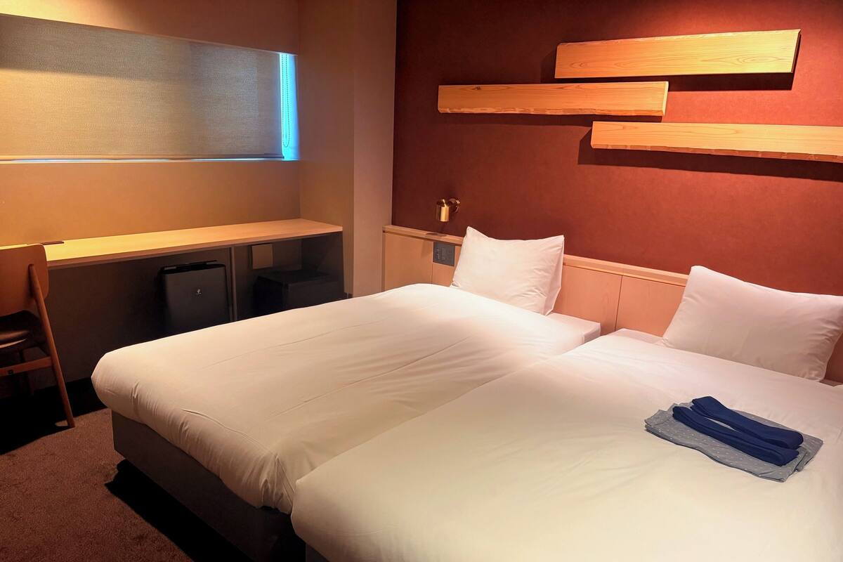 Una habitación de hotel con una cama grande, un escritorio y una silla.