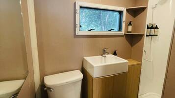 A compact bathroom with a toilet, sink, and window.