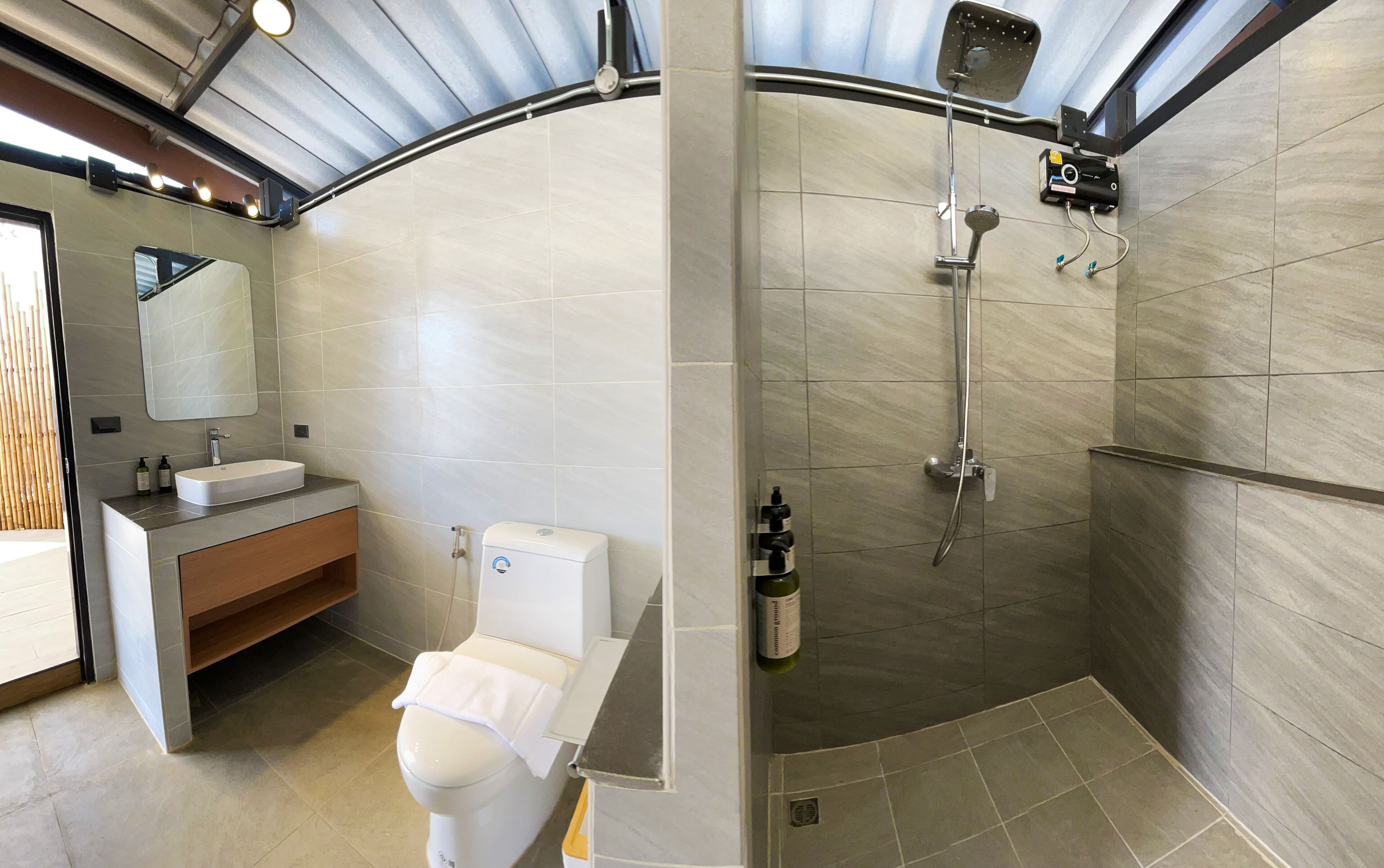 A modern bathroom with a toilet, sink, and shower.