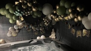 Un bain à remous agrémenté d’une décoration composée de ballons et de chiffres, ce qui pourrait indiquer une célébration ou un événement.