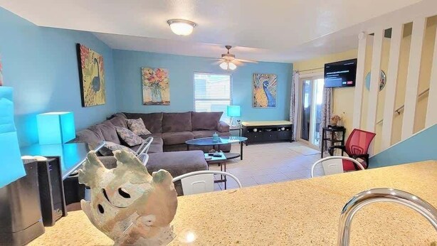 A living room with a sofa, coffee table, and a TV. - Habitat #23 1 Bedroom Home by RedAwning (South Padre Island)