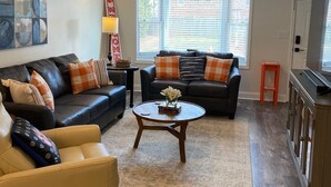 A living room with two sofas, a coffee table, and a TV stand.