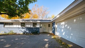 Un garage d’habitation avec une porte blanche et une porte de garage bleue.