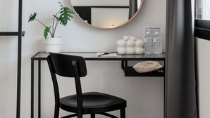 A compact workspace with a round mirror, a potted plant, and a small desk. - CASA BLANCA Dusit - Hostel (Bangkok)