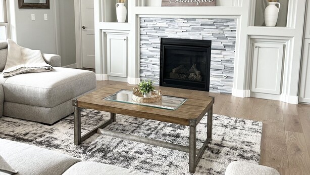 A modern living room with a fireplace, a flat-screen TV, and a comfortable seating area. - Comfort by Southridge (Kennewick)