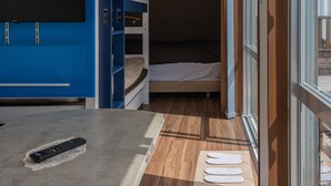 Une chambre avec un lit superposé, un bureau avec une télécommande et une fenêtre donnant sur un beau paysage.