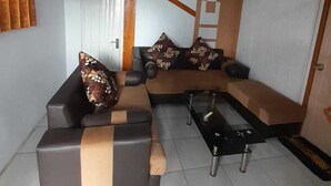 Una sala moderna con un sofá modular, una mesa de centro y un televisor.
