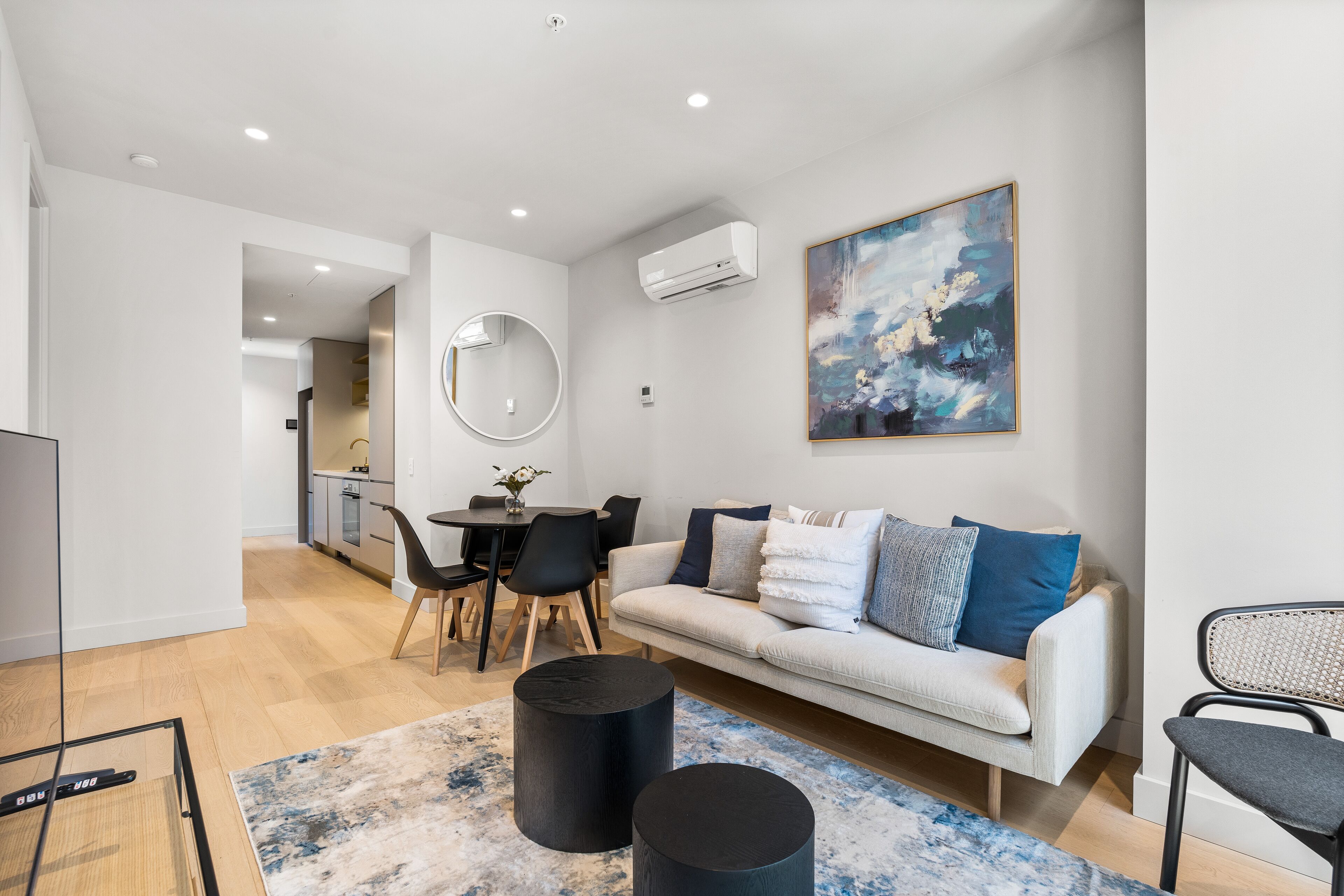 Un salon moderne avec un canapé, une table basse et un coin repas comprenant des chaises et une table.