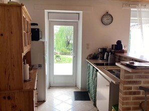 Eine Küche mit Kühlschrank, Herd und Kaffeemaschine.