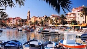 Una marina con barcos amarrados, una iglesia y edificios a lo largo de la costa.