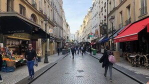 A cobblestone street lined with shops and cafes, with pedestrians walking on the sidewalk. - Paris Studio atypique - Place des victoires (Paris)