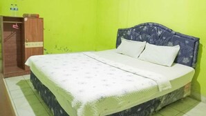 Quarto com cama, guarda-roupa e parede verde.