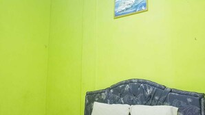 Quarto com cama, ar-condicionado fixado na parede e quadro emoldurado.