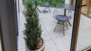 A modern indoor patio with a green wall, two tables, and chairs. - Inn Boutique León (León)