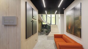 A modern interior with a staircase, a wooden wall, and a sofa. - Inn Boutique León (León)