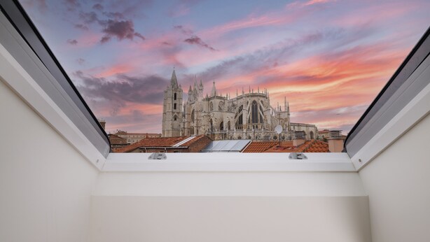 A view from a window overlooking a historic cathedral with intricate architecture, a clear sky, and a glimpse of the surrounding rooftops. - Inn Boutique León (León)