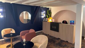 A reception area with a wooden desk, a round mirror, and two chairs. - Thoiry Etoile Lodge, Sure Hotel Collection by Best Western (Thoiry)