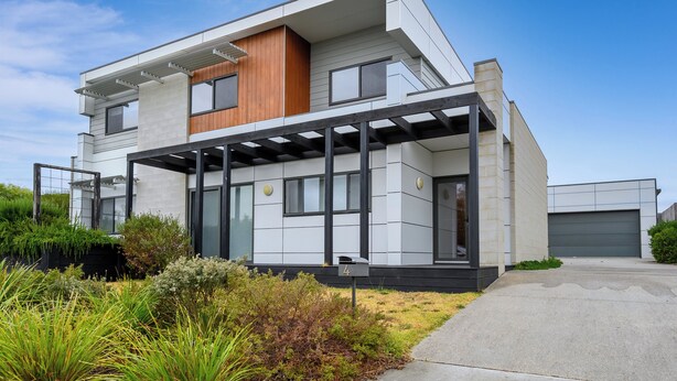 A modern two-story house with a covered porch, a garage, and a well-maintained garden. - Whales & Wombats (Bass Coast)