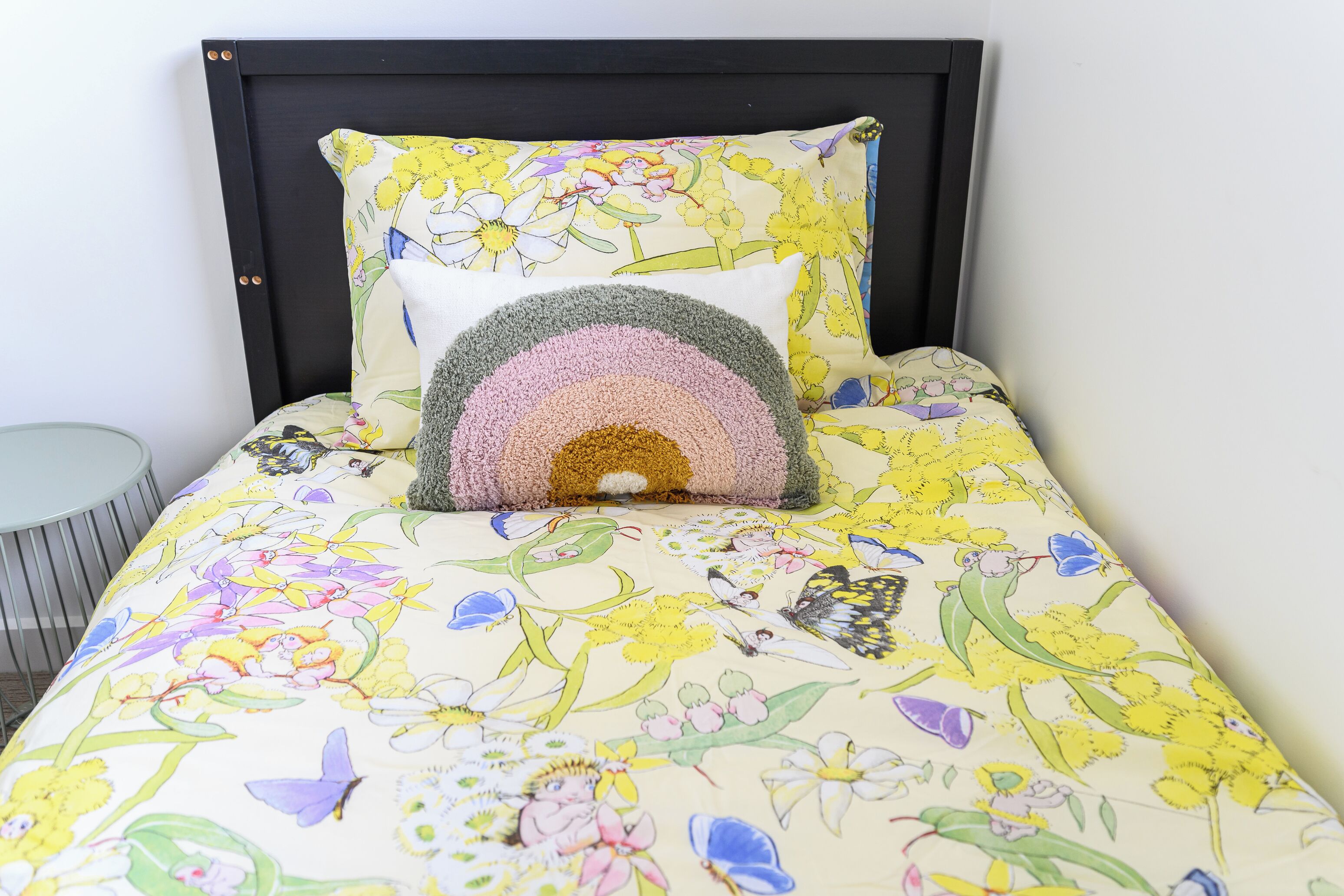 Una cama con ropa de cama floral y un cabecero.