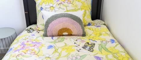 Una cama con ropa de cama floral y un cabecero.