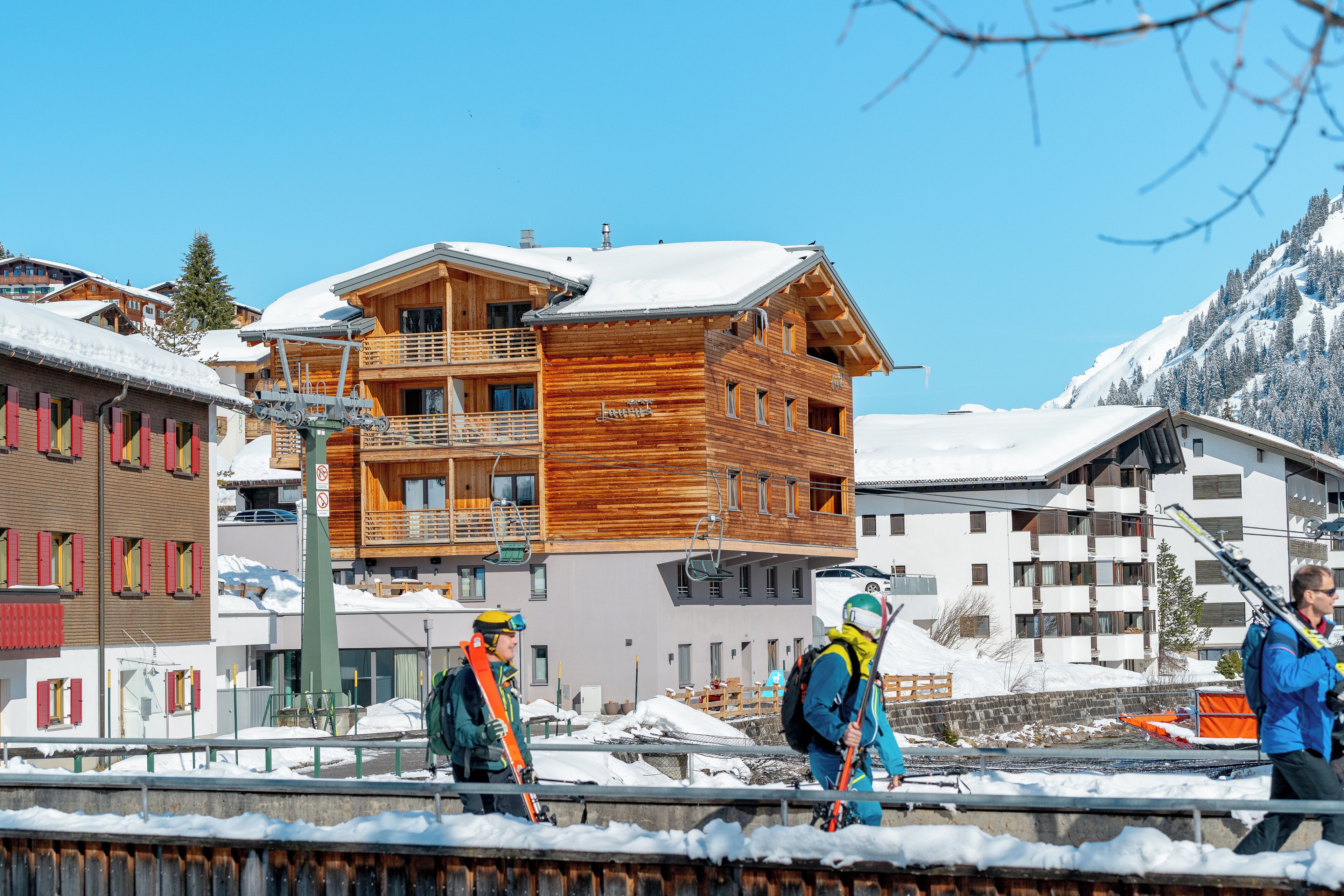 Un edificio de madera de varios pisos con balcones y teleféricos, rodeado de terreno cubierto de nieve.