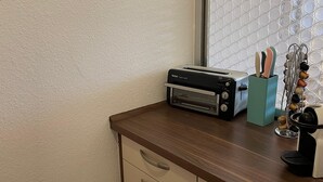 A kitchen with a toaster on the counter, a window with a textured pattern, and a drawer unit with handles. - Apartment Thermen-zeit (Bad Fuessing)