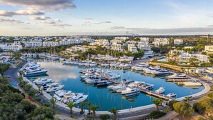 A marina with numerous boats docked, surrounded by residential buildings and greenery. - Bella Maria Apartments & Pool Club (Felanitx)