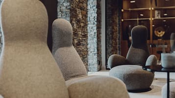A modern interior with plush, textured seating and a stone accent wall.