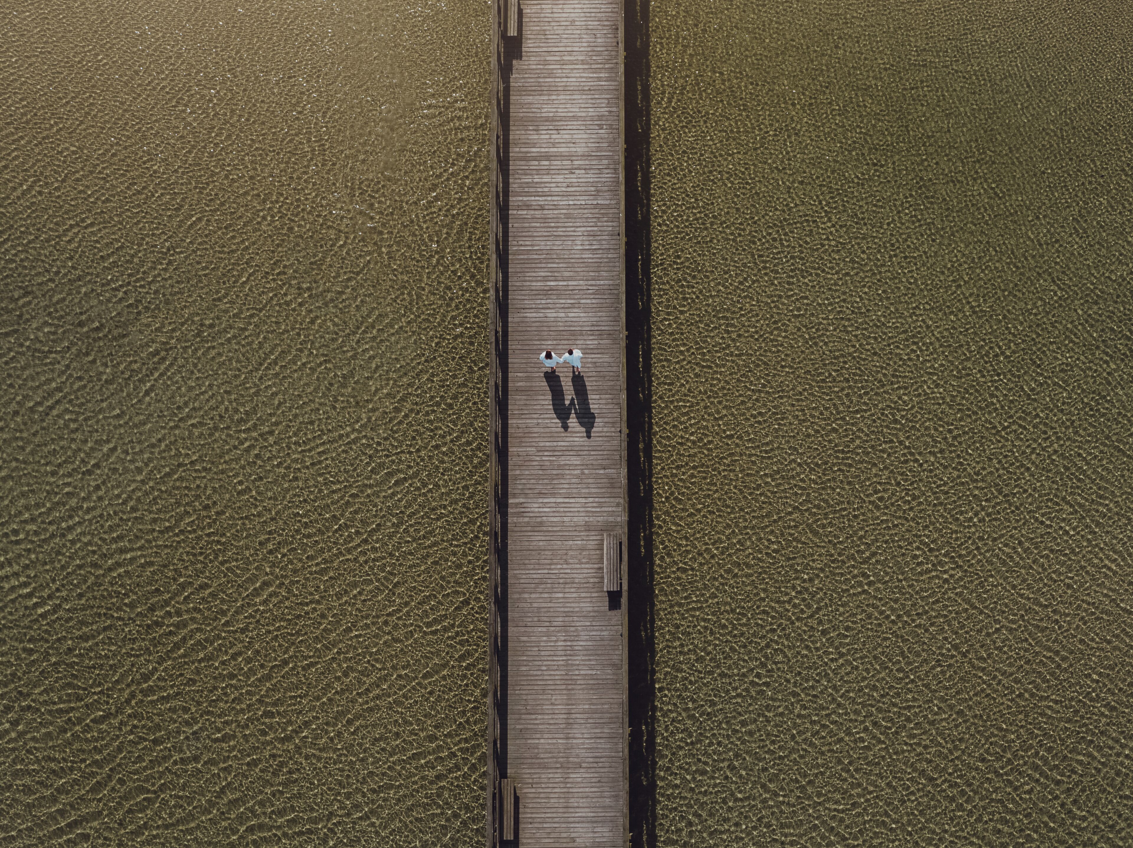 Vue aérienne d’une jetée en bois s’étendant dans une étendue d’eau.