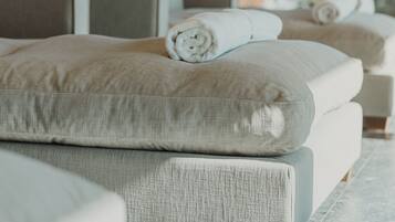 A spa room with a large window, a massage table, and a towel on the bed.