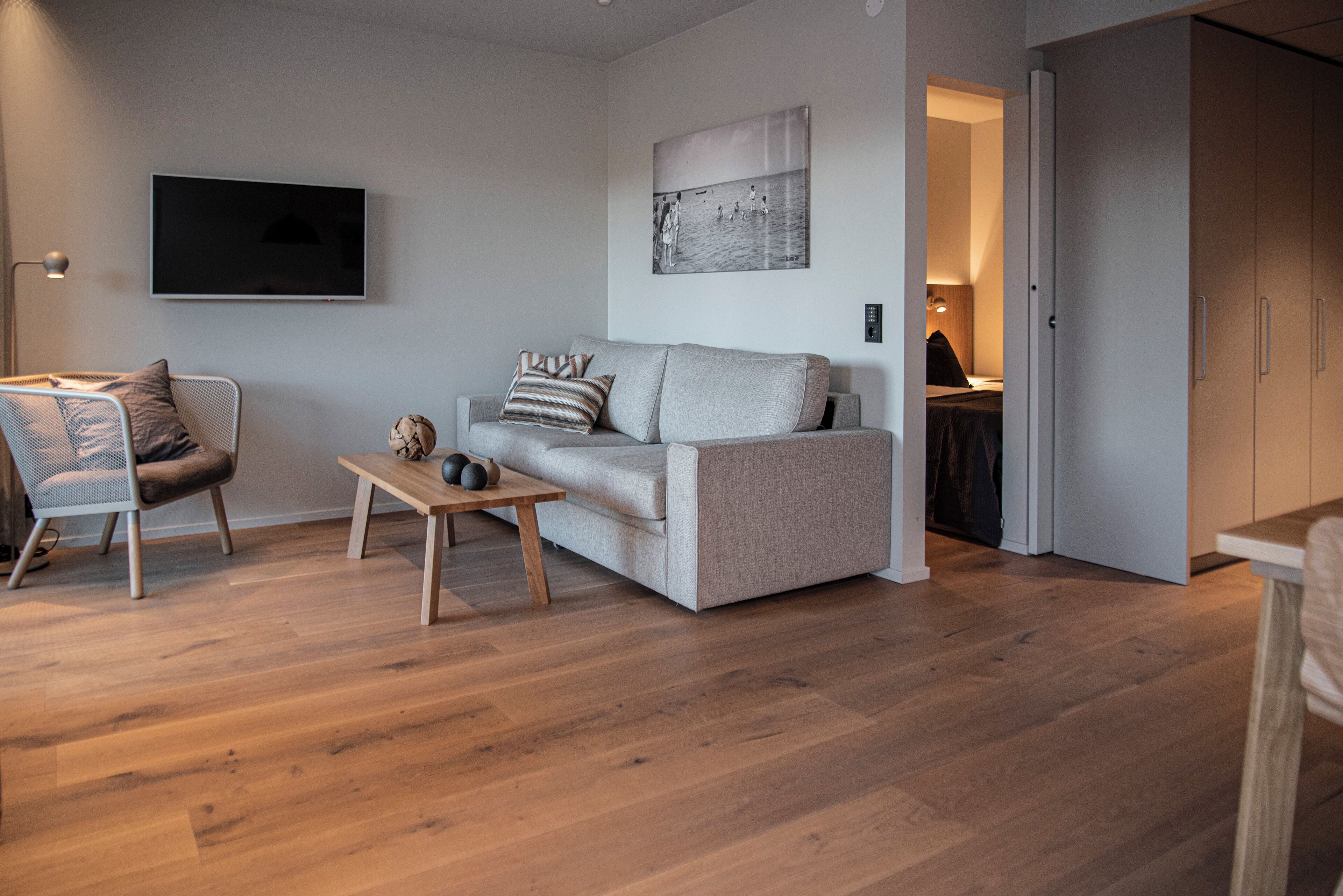 Una sala de estar moderna con un sofá, una mesa de centro y un televisor.
