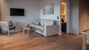 Una sala de estar moderna con un sofá, una mesa de centro y un televisor.
