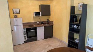 A compact kitchen with a refrigerator, oven, microwave, and dishwasher.