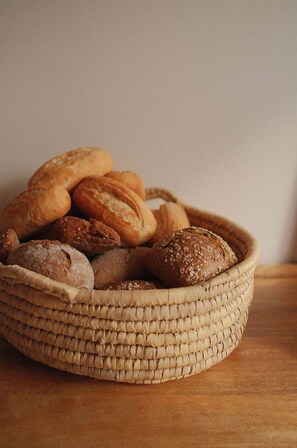A woven basket filled with various types of bread. - Vino Resort Son Amaret (Manacor)