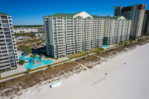 Un hôtel de grande hauteur doté de nombreux balcons, d’une piscine et offrant une vue sur la plage.