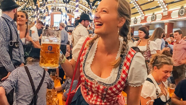 Een drukke binnenshuis gelegenheid met mensen in traditionele kleding, waarschijnlijk tijdens een cultureel of feestelijk evenement.