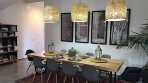 A dining area with a long wooden table, six chairs, and three hanging wicker chandeliers. - Villa Cactus, 5 Chambres, Piscine Chaufée (Marrakech)