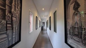 A hallway with framed pictures on the walls, leading to a door at the end. - Villa Cactus, 5 Chambres, Piscine Chaufée (Marrakech)