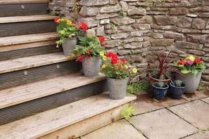A stone wall and steps with potted plants.