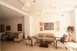 A spacious living area with a beige sofa set, a coffee table, and modern pendant lighting. - Downtown Tunis Hotel (Tunis)