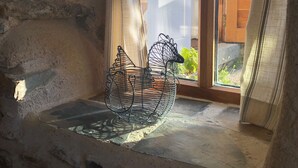 A rustic stone interior with a woven basket hanging by a window. - Cosy cottage, peaceful setting 5 mins to beautiful sandy beach & fabulous walks! (Mawgan Porth, Cornwall)