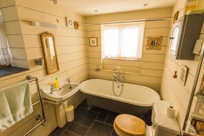 A bathroom with a bathtub, sink, toilet, and a window with curtains. - Cosy cottage, peaceful setting 5 mins to beautiful sandy beach & fabulous walks! (Mawgan Porth, Cornwall)