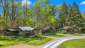 Eine Reihe von Hütten, verbunden durch einen Kiesweg, umgeben von üppiger Vegetation und Bäumen.